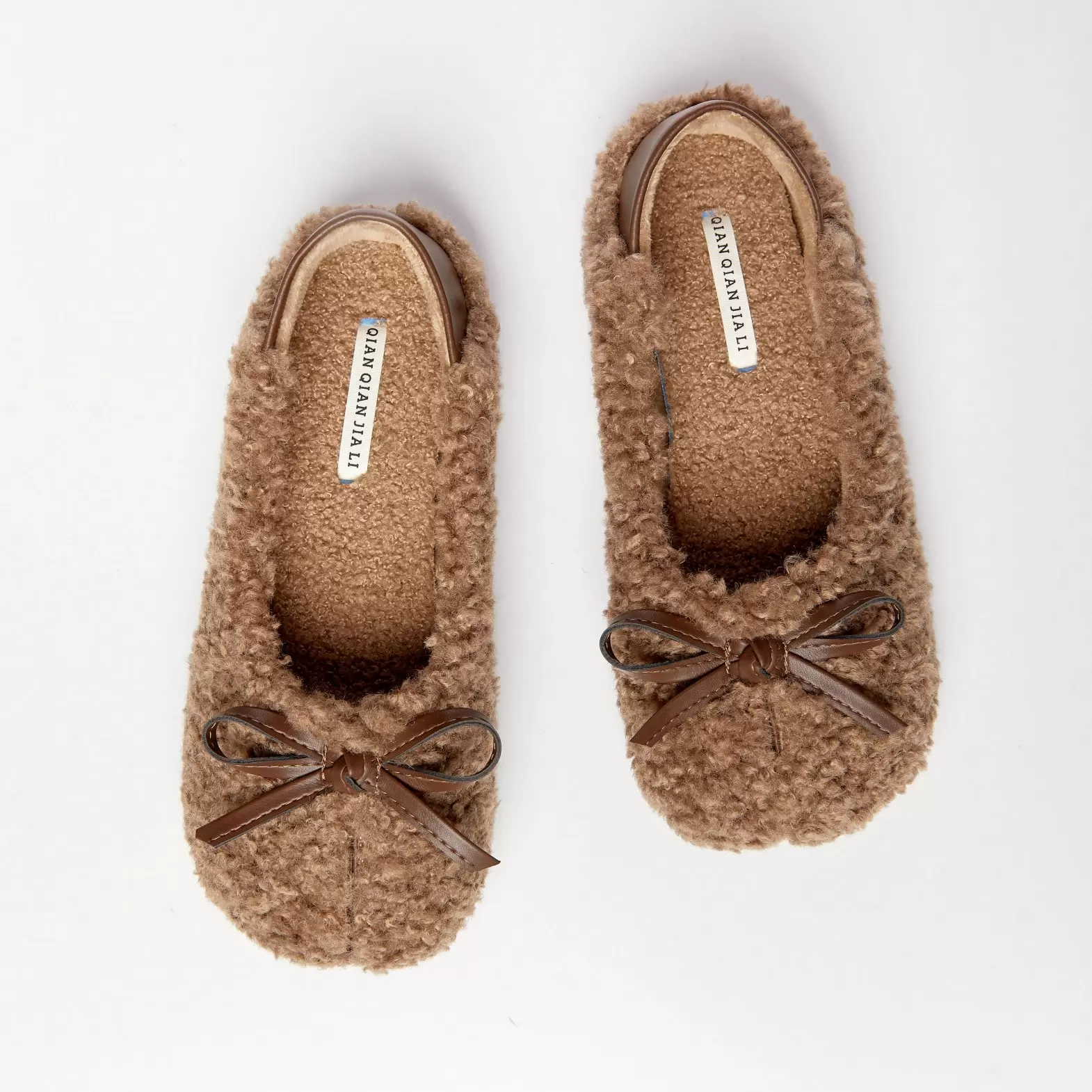 Homemade slippers made of artificial plush with beige bows